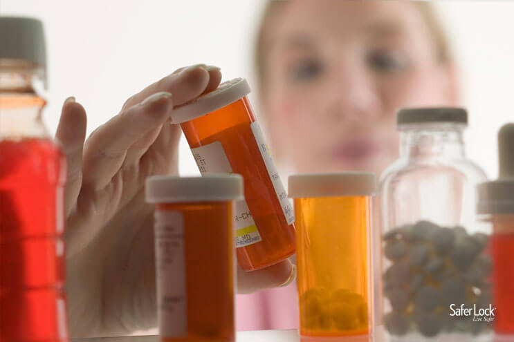 A woman looking through the contents of a medicine cabinet.