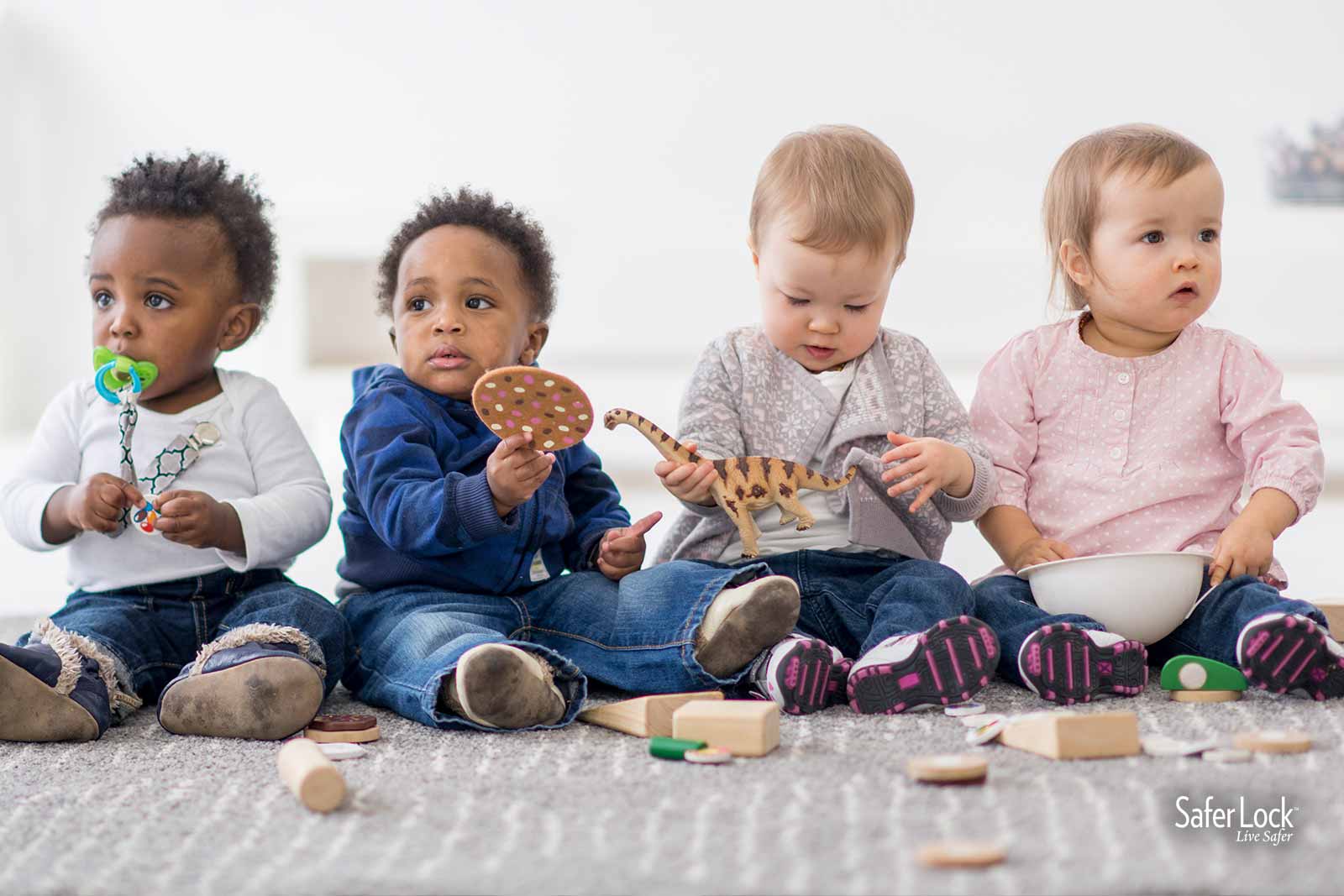 Group of babies playing. Learn about baby safety tips during Baby Safety Month at Safer Lock.