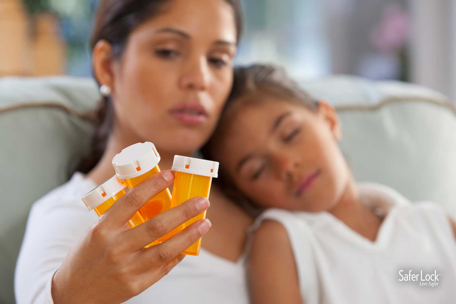 A worried mom holding her daughter looks at empty rx bottles. Find out how Safer Lock and Disposes Rx are protecting kids from medicine poisoning.