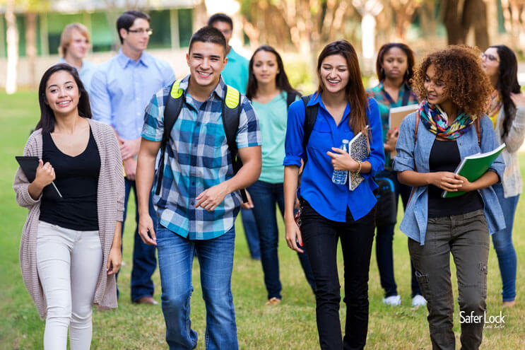 A group of teenagers in conversation walking across a high school campus.