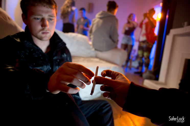 A teenage boy accepting a joint at a house party.
