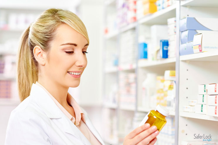 A female pharmacist inspects a prescription bottle in a pharmacy.