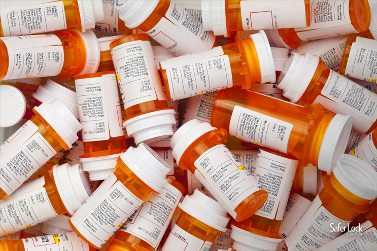 Photo of many orange pharmaceutical bottles with white labels and white caps.